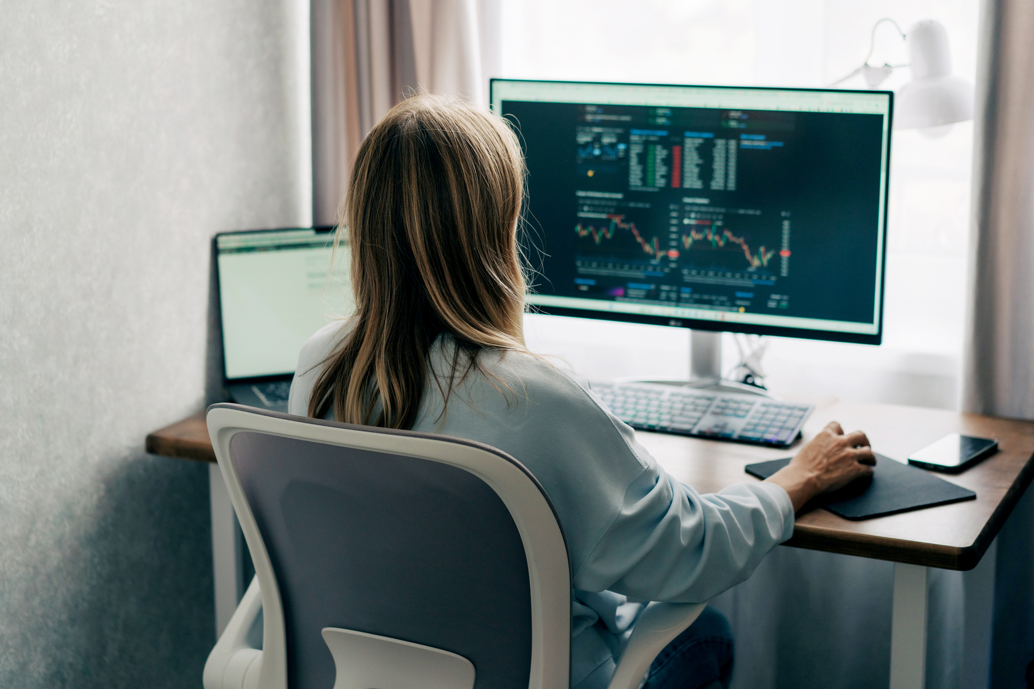 Image of woman trading financial markets in her home office